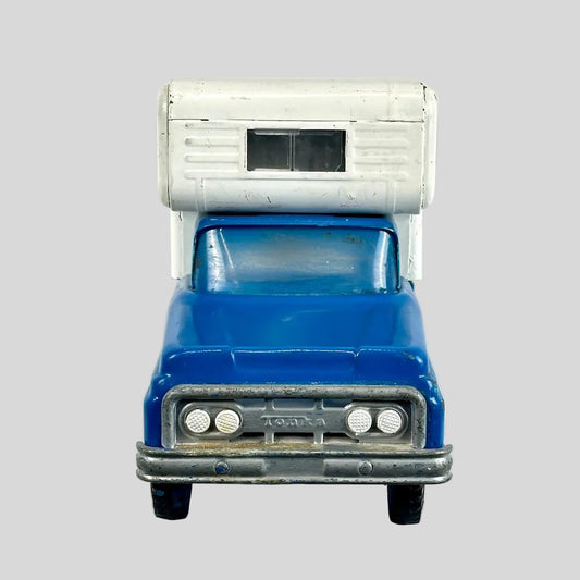 Blue toy truck with a silver camper top on a gray background
