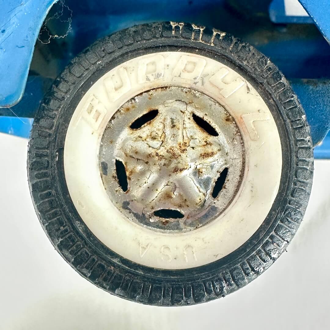Close-up of a toy tire with Buddy L branding on a white background