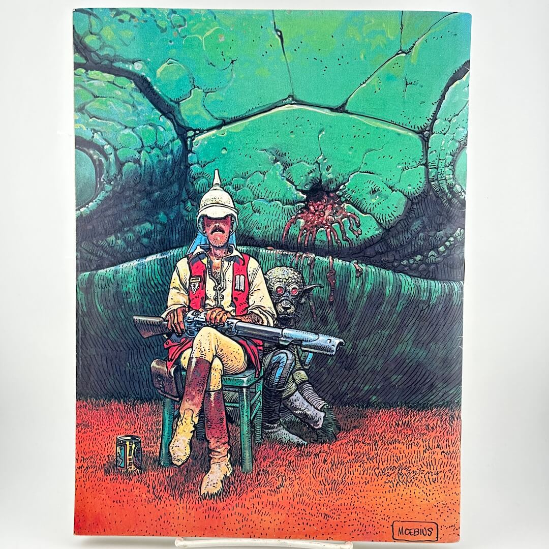 Back of magazine with illustration of man sitting with gun on his lap with an alien crouched behind him.