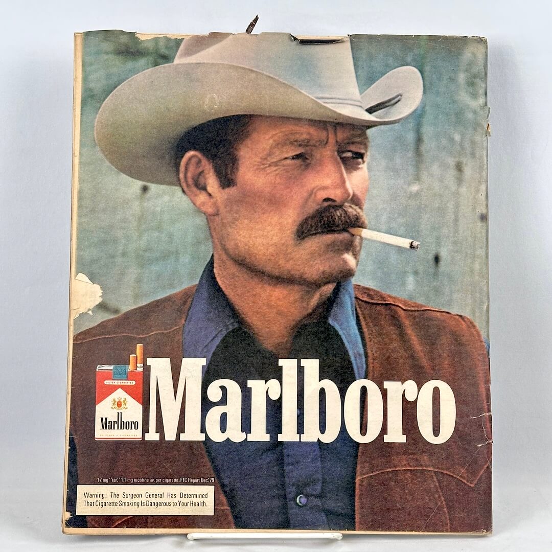 Vintage Marlboro cigarette ad featuring a portrait of a cowboy with a mustache smoking a cigarette.