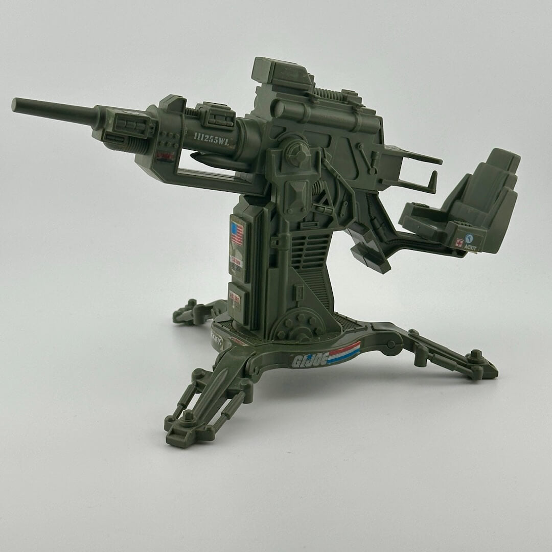 Army green anti aircraft cannon style gun with seat. Features G.I. Joe and American flag stickers.