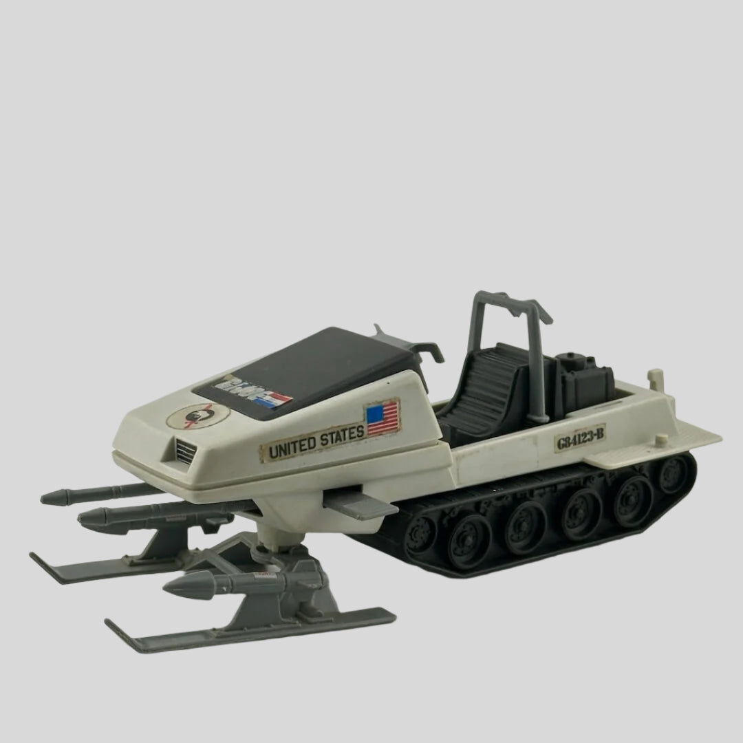 White & grey snowmobile with black tracks, grey missiles on either leg, double gun at nose, & G.I. Joe sticker decals.
