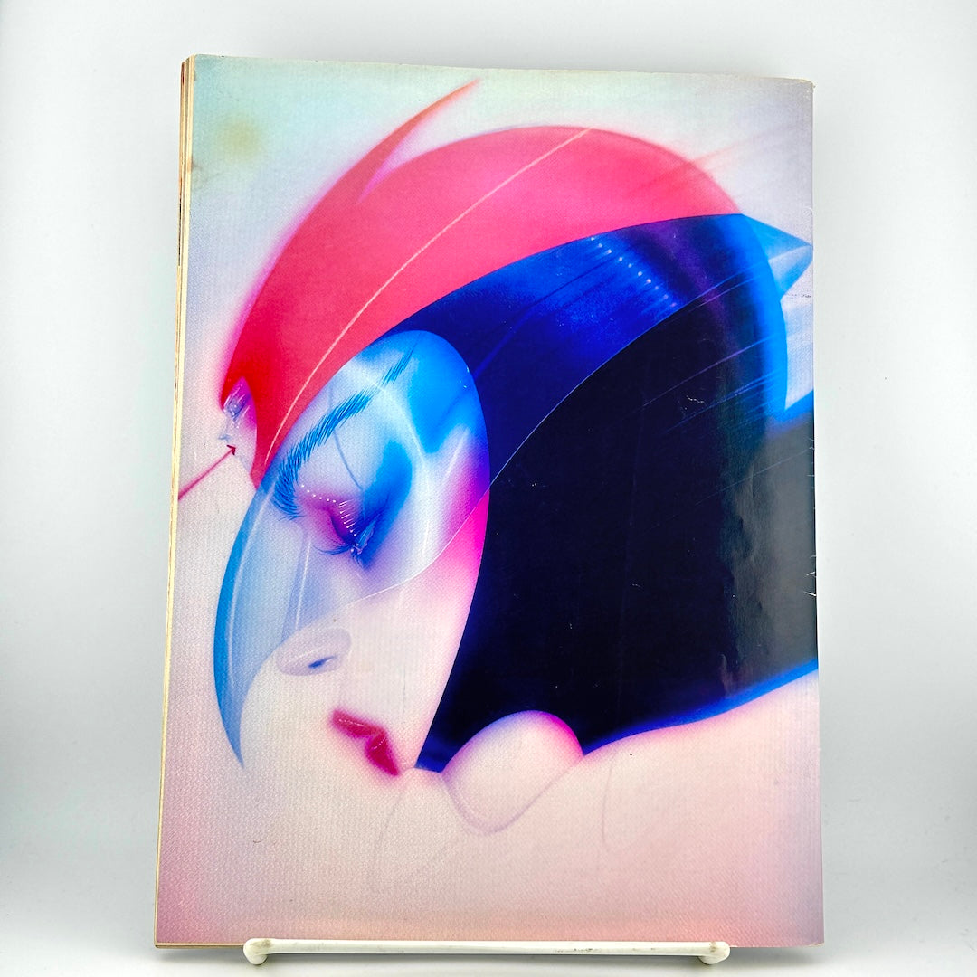 Back cover of magazine featuring a stylized, abstract portrait of a face with a red helmet and blue visor.