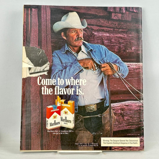 Back cover of magazine with full page ad for Marlboro cigarettes with image of smoking cowboy leaning against barn.