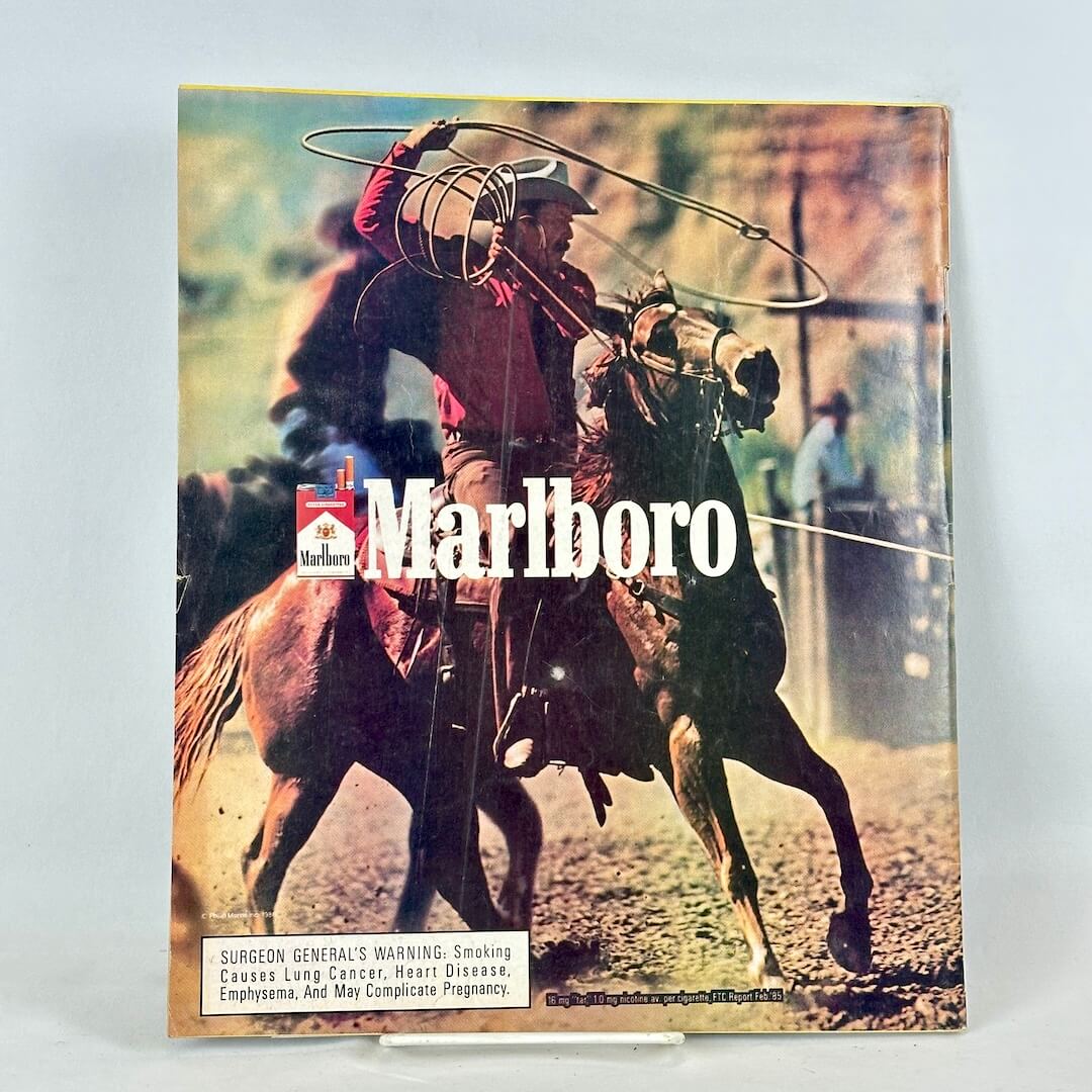 Back cover of magazine with full page ad for Marlboro cigarettes featuring roping cowboy on horseback.