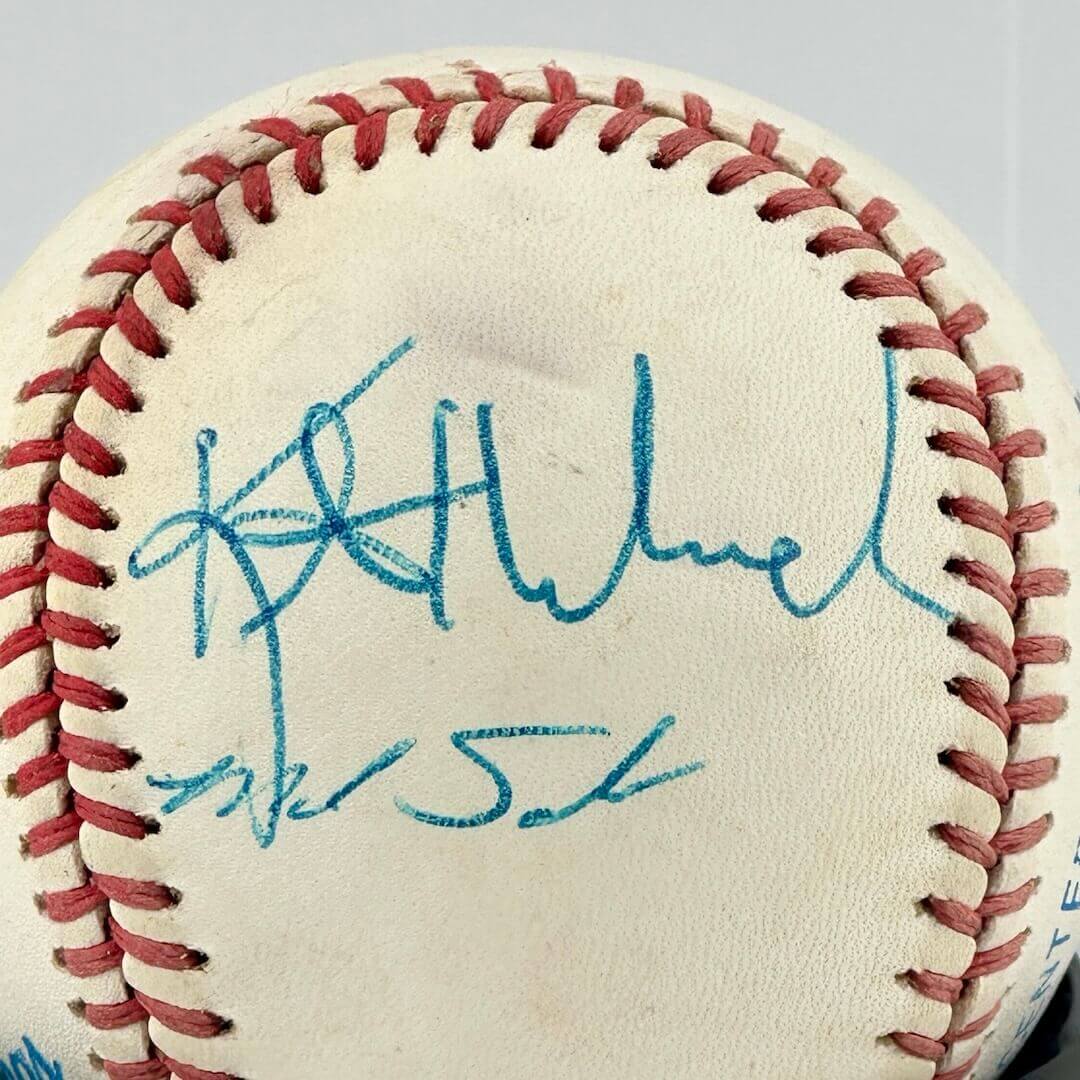 White baseball with two hand signatures in blue ink.