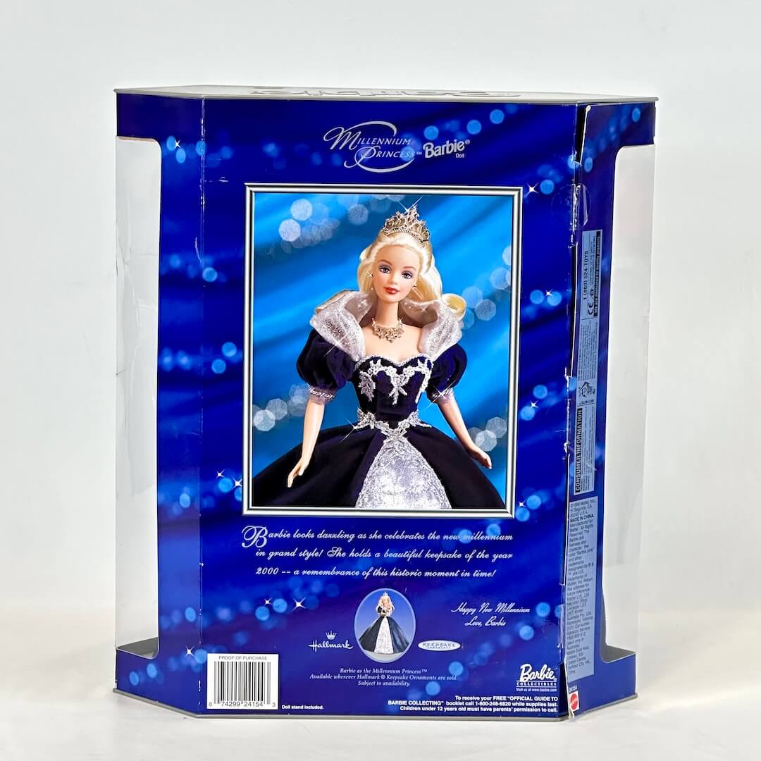 Barbie doll in a blue dress with a tiara in a packaging box on a white background