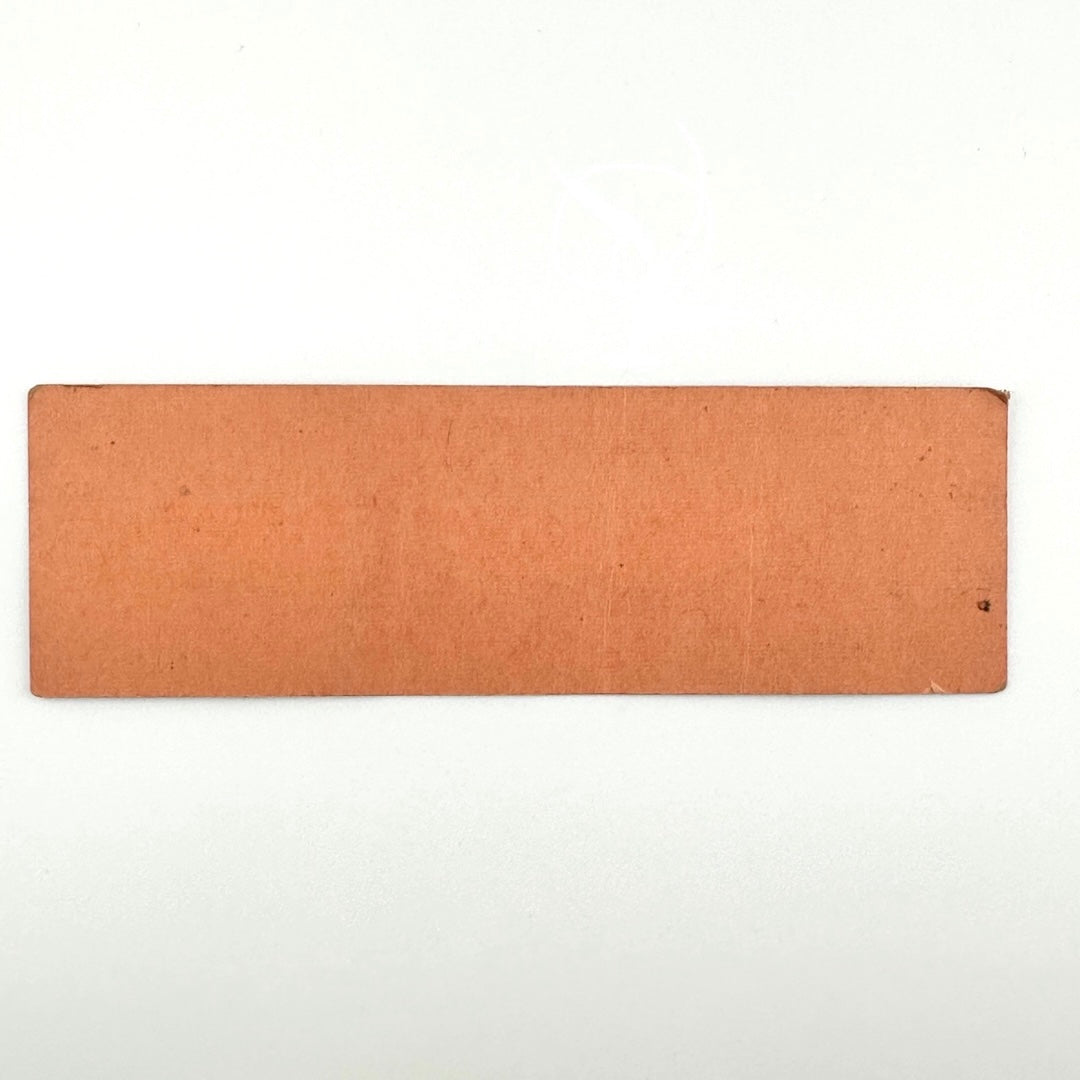 Backside of orange rectangular ticket with some ink transfer and a small amount of dirt, one rolled corner, no other wear.
