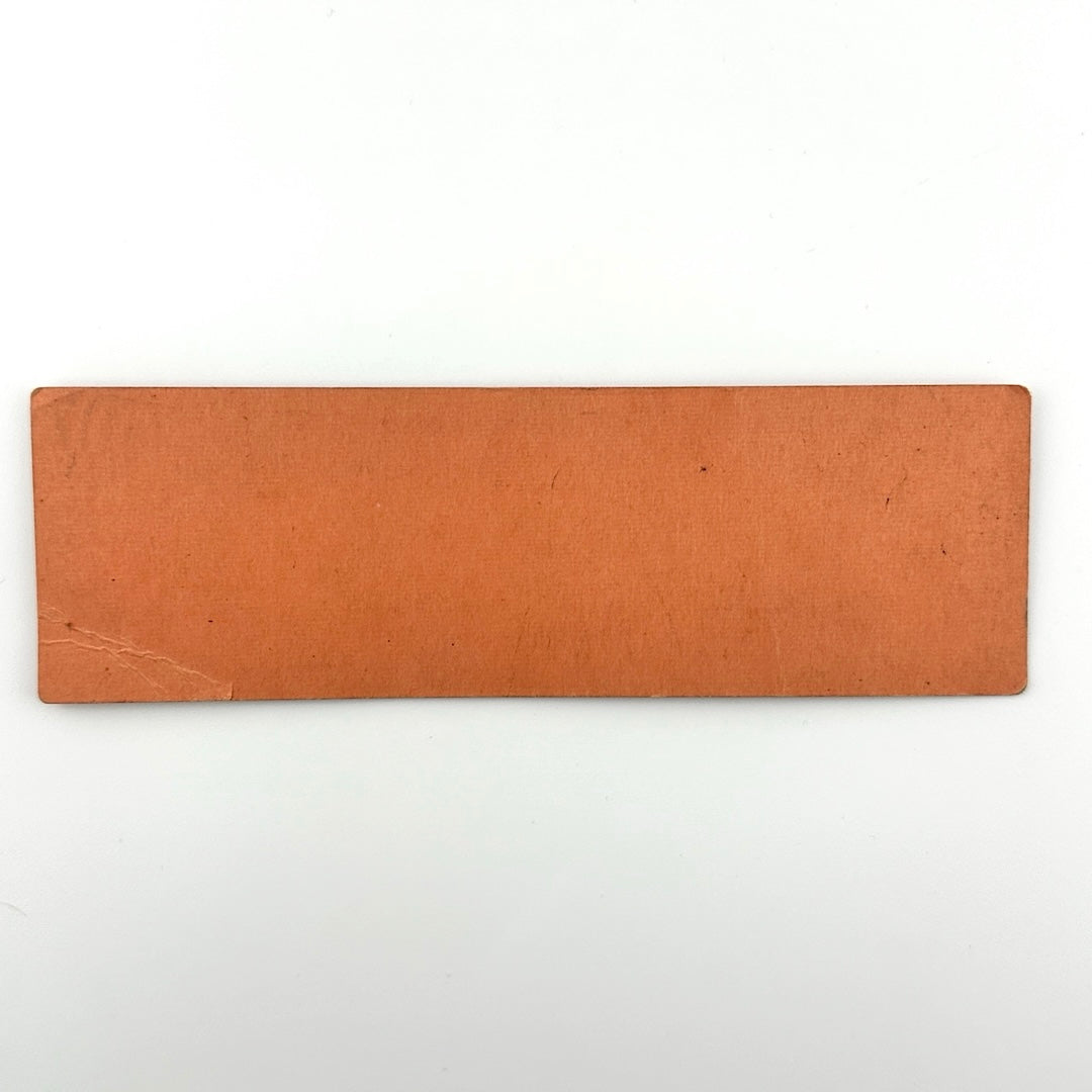 Backside of orange rectangular ticket with one creased corner but no other damage or wear.