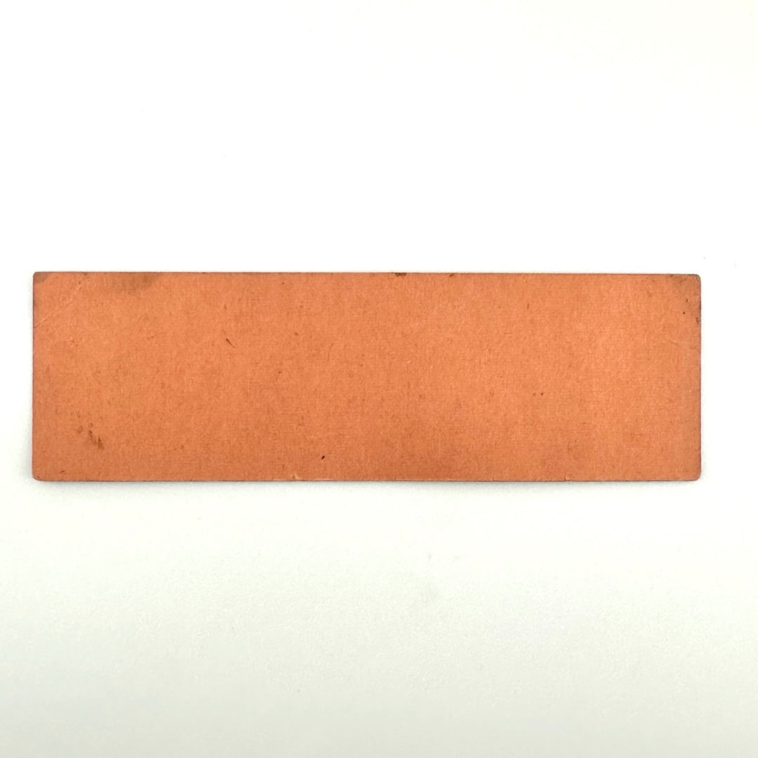 Backside of orange rectangular ticket with a small amount of dirt, no other damage.