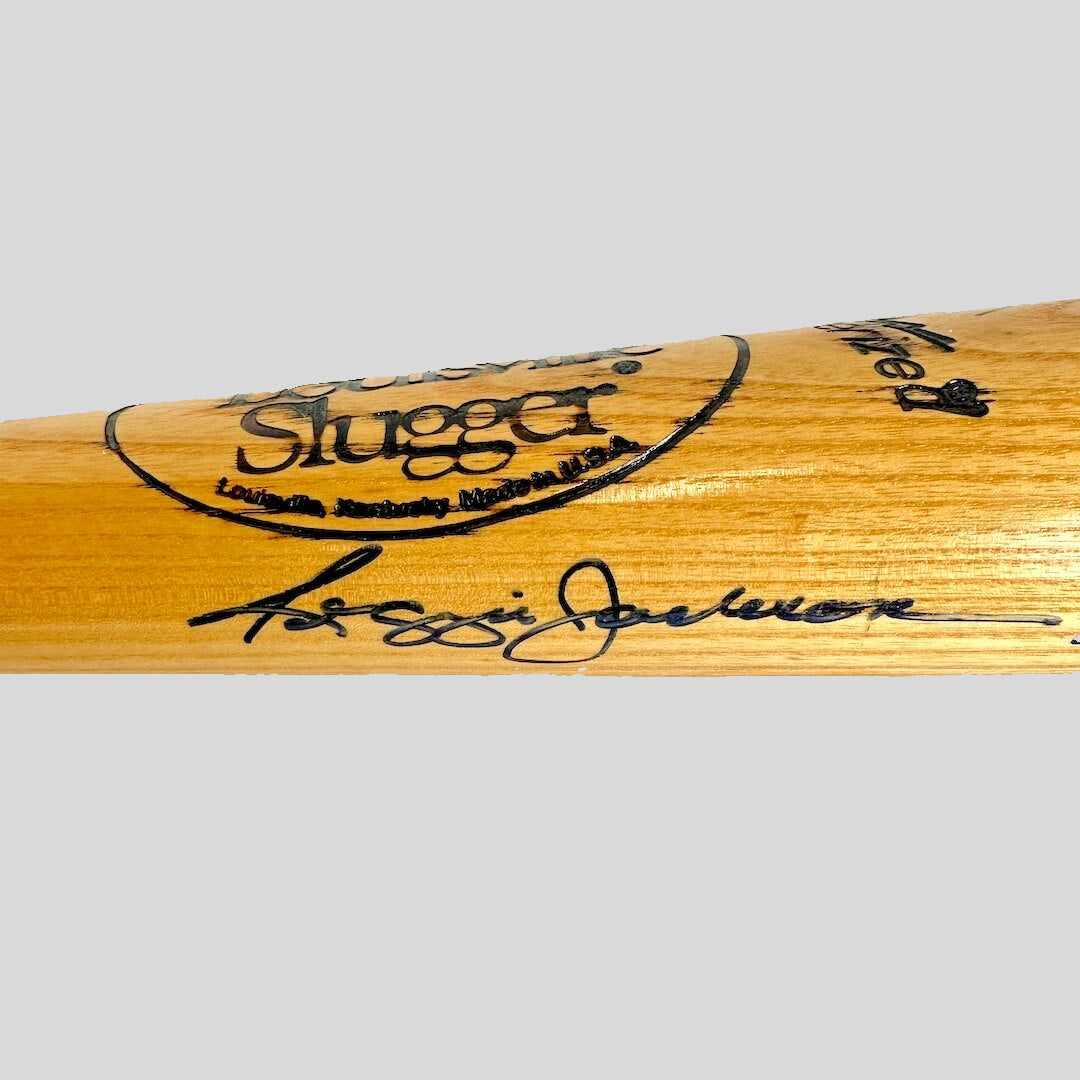 Wooden baseball bat with 'Sluggerr' branding and signature on a gray background