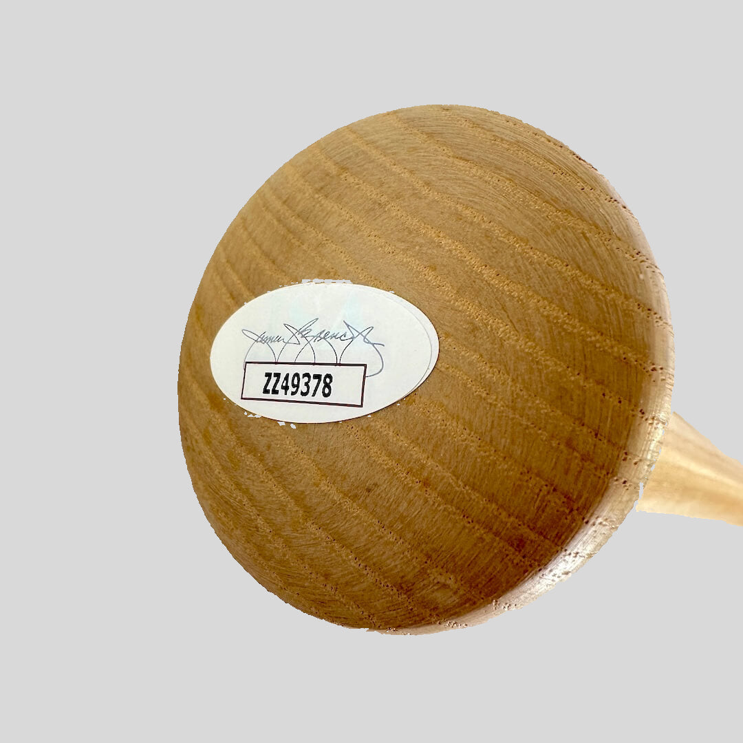 Wooden baseball bat knob with JSA authentication sticker on a gray background