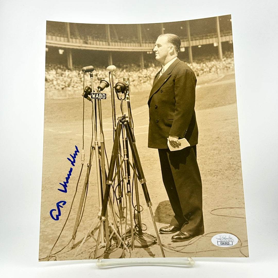 Vintage photograph of a man standing next to microphones on a baseball field, JSA sticker in bottom corner "CG62923."
