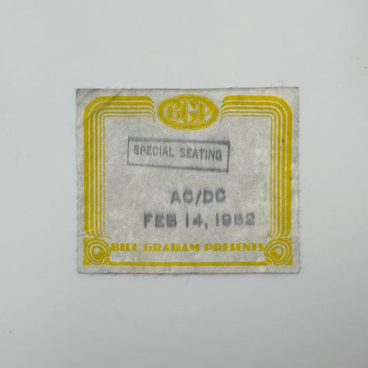 Rectangular fabric backstage pass with yellow border and black stamped event info.