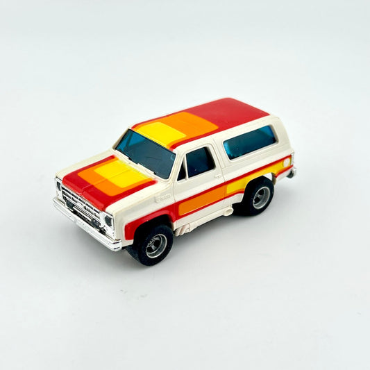 Model of a vintage SUV with red, yellow, and white stripes on a white background