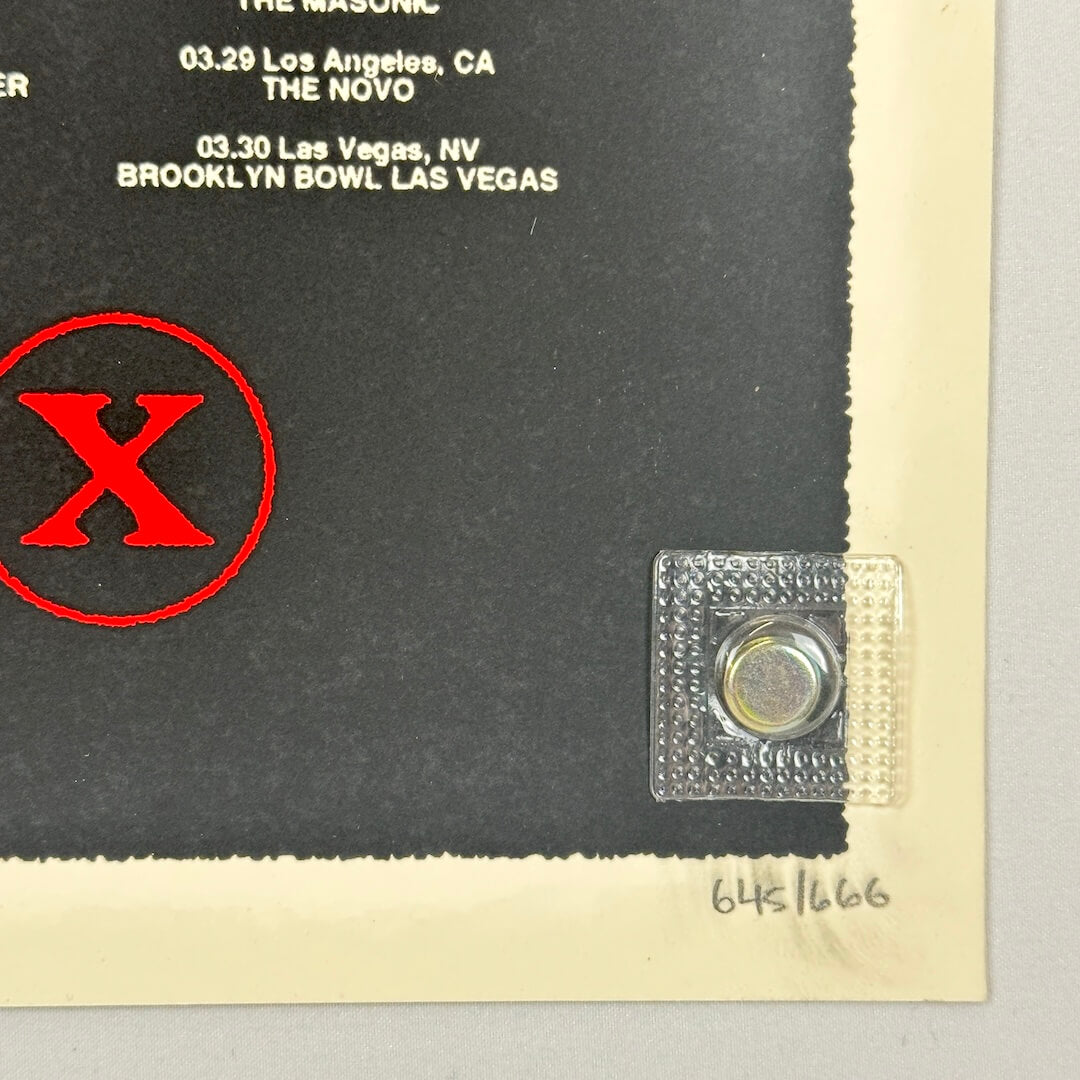 Promotional poster with red 'X' logo and concert information on a black background, penciled poster number in corner.