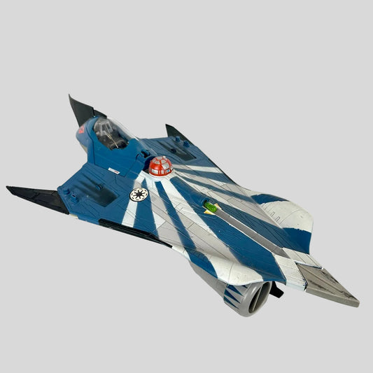 A toy model of a futuristic delta-wing fighter jet, featuring a blue and white striped pattern with black accents.