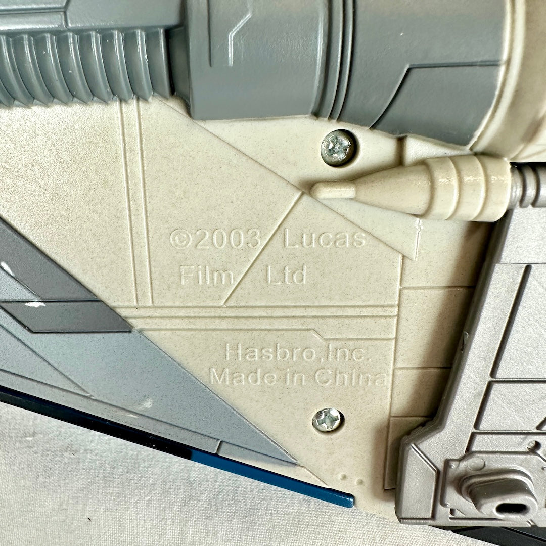 Close-up of a beige and gray molded plastic toy with embossed text reading 'LucasFilm Ltd' and 'Hasbro, Inc.'