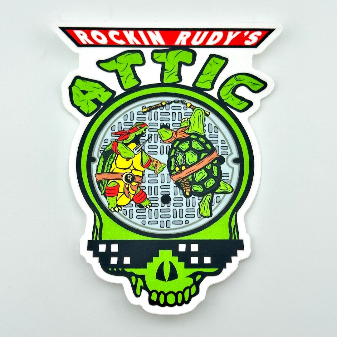 Decorative sticker with TMNT stylized Grateful Dead terrapin turtles and 'Rockin Rudy's Attic' text on a light gray background.