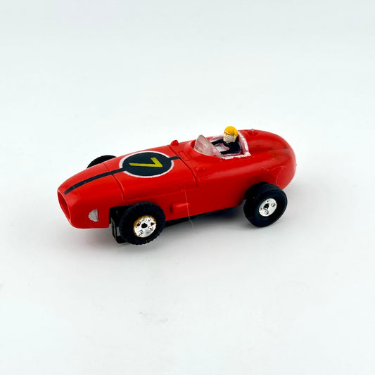 Red slot car with driver against white background.