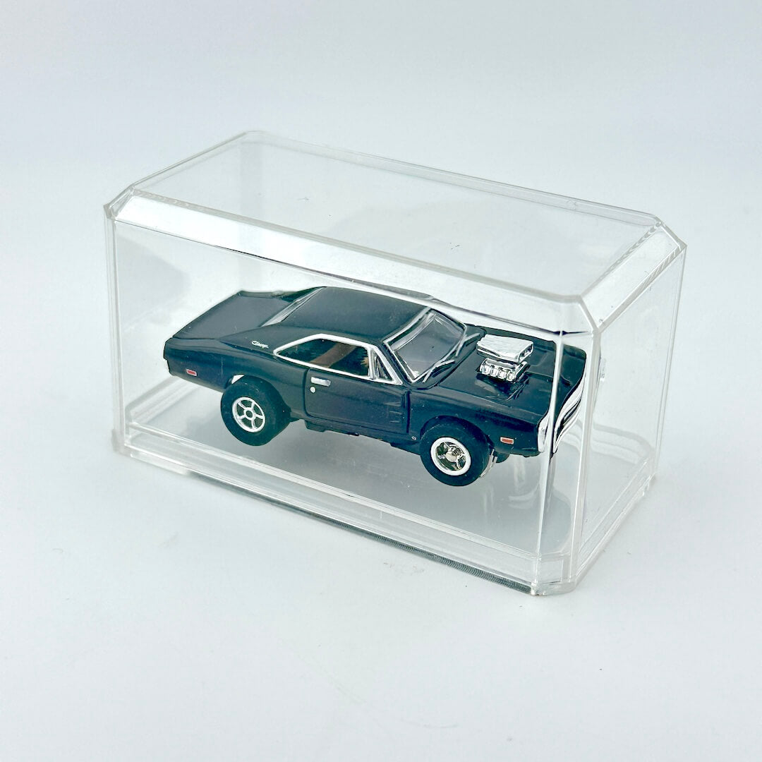 Black toy car inside clear rectangular display case.