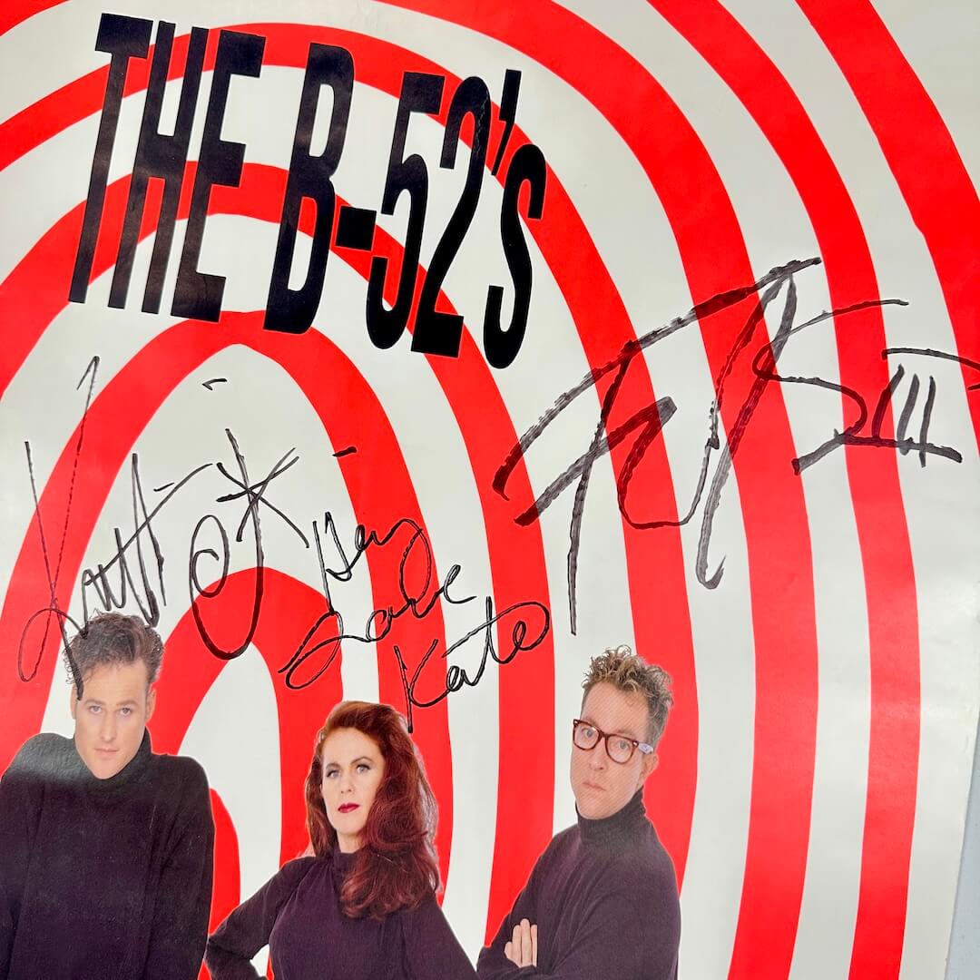 Close up of signature portion of poster under artist name and above their heads.