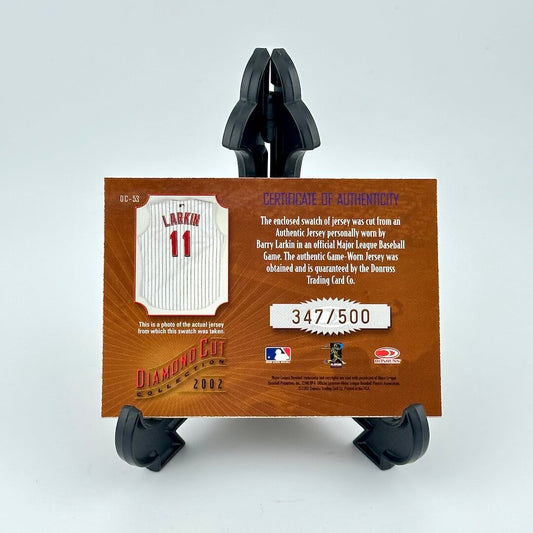Baseball jersey card with a certificate of authenticity on a stand against a light gray background
