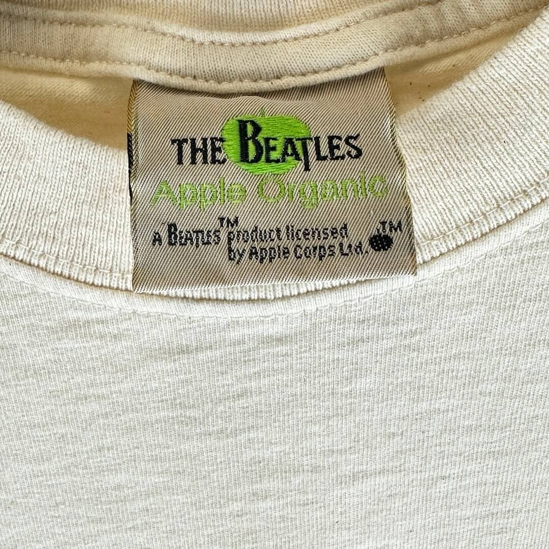 Close up of back neck tag with official licensing for Beatles, their logo, Apple Organic.