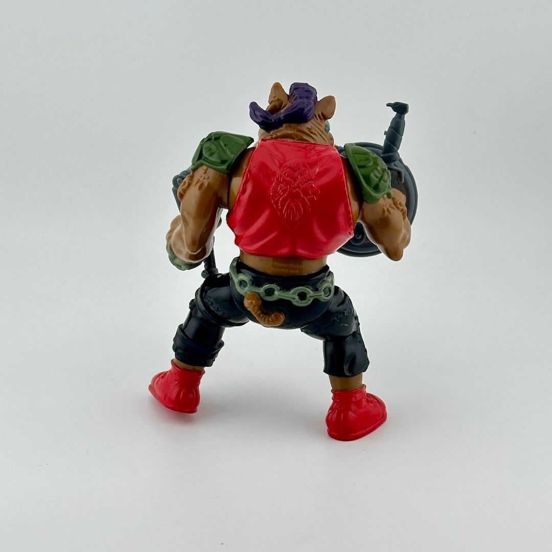 Anthropomorphic hog in pants, vest, with nosering & armor, holding gun, knife & sewer lid shield. Back.