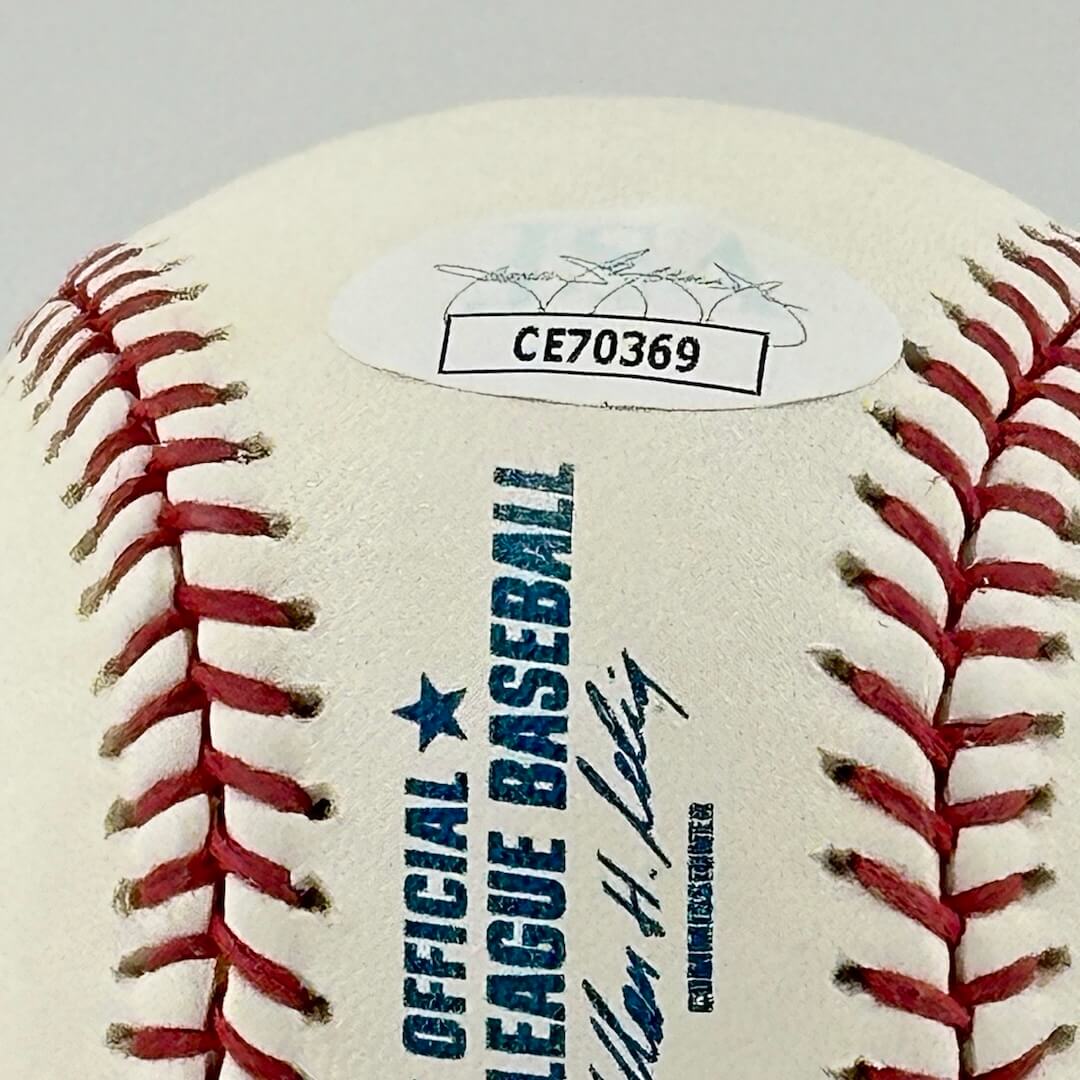 Close up of JSA authentication sticker next to MLB ball information stamp.