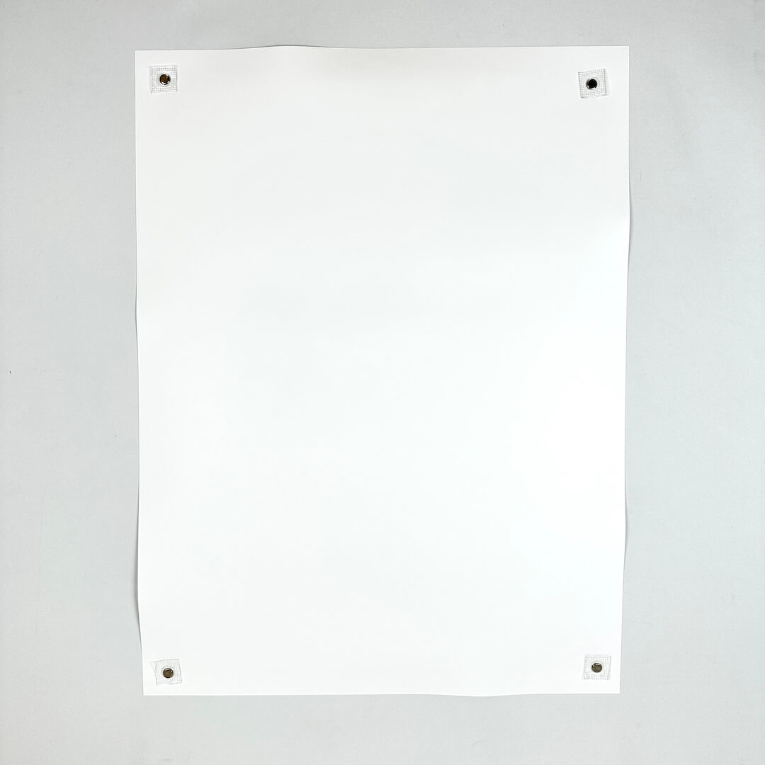 Backside of white poster showing no damage to face, corners, or edges, against white background.