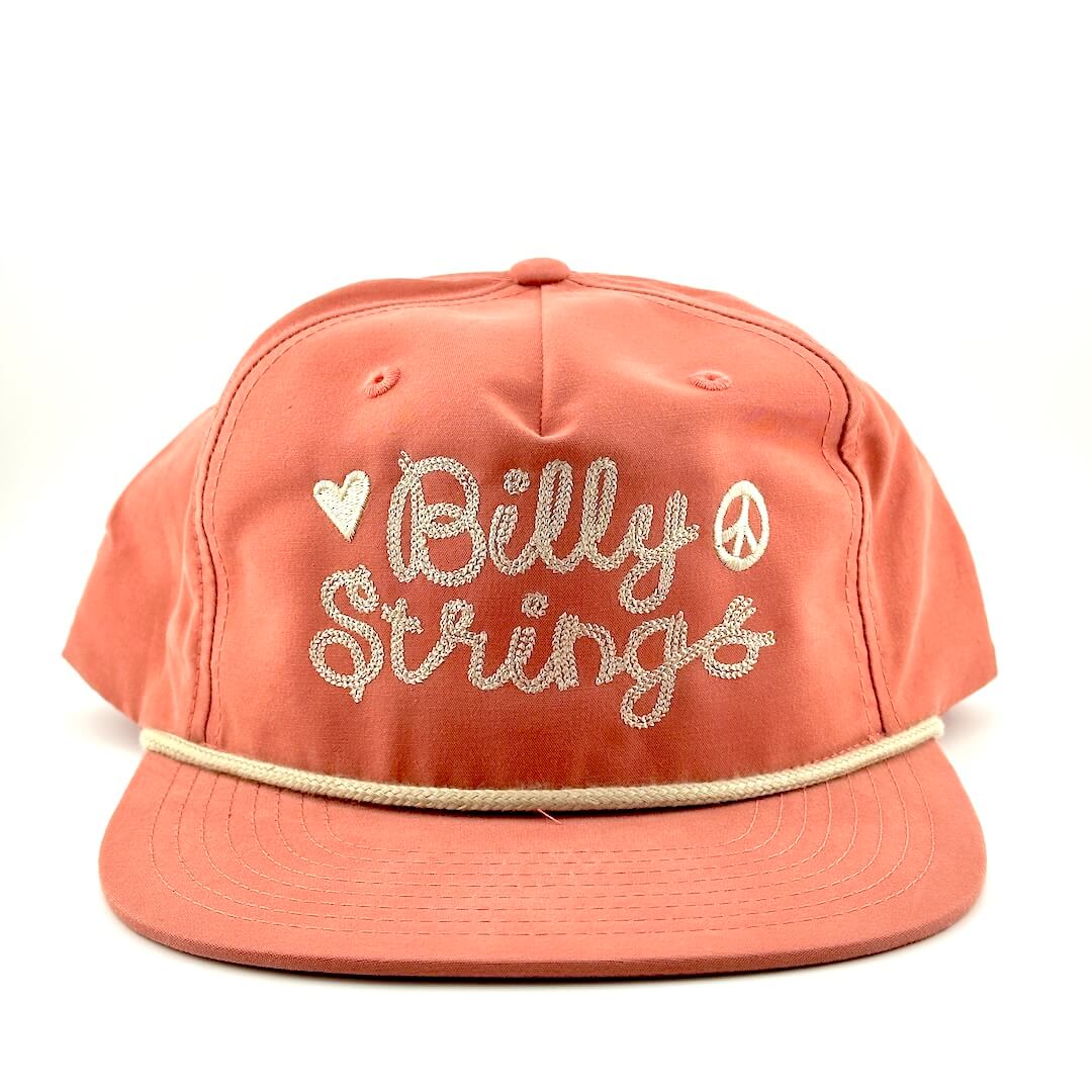 Peach-colored cap with 'Billy Strings' text and decorative elements on a white background