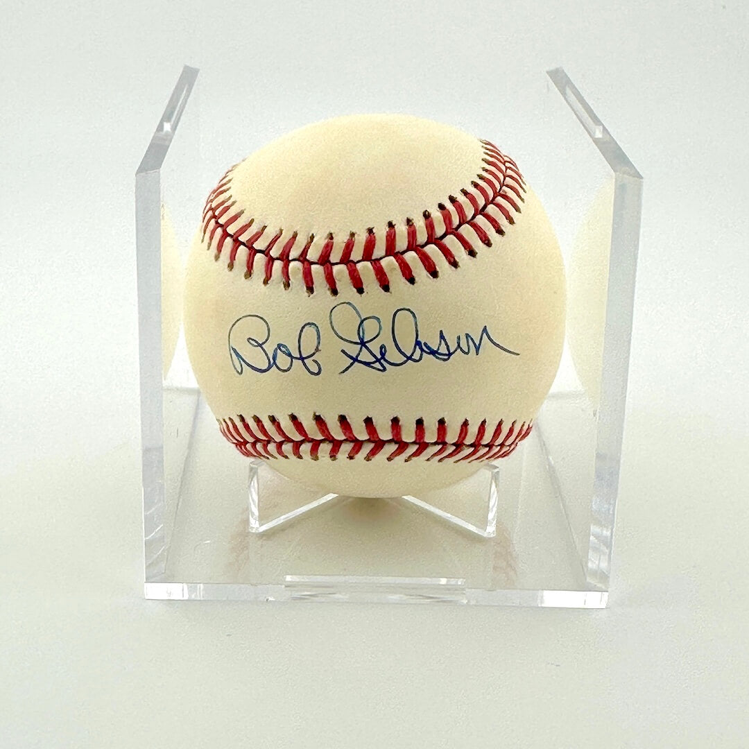 Signed baseball in clear display cube against white background.