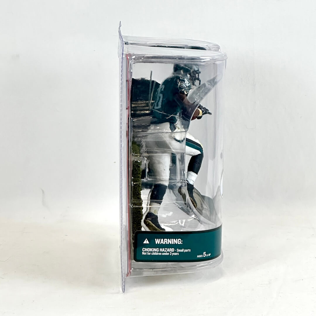 Toy figure in clear packaging with a warning label on a white background