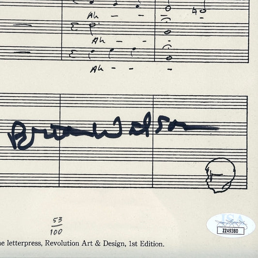A close-up of a printed sheet music page with musical notation, handwritten musical notes, a signature, and an authentication sticker in the lower right corner.
