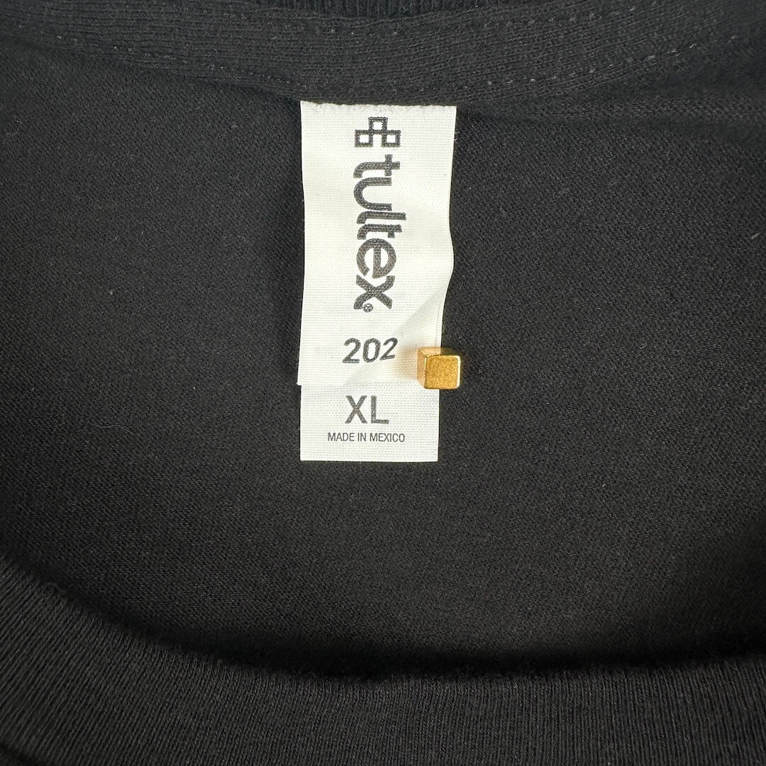 Close-up of a black knit garment neck label reading Tultex, size XL.