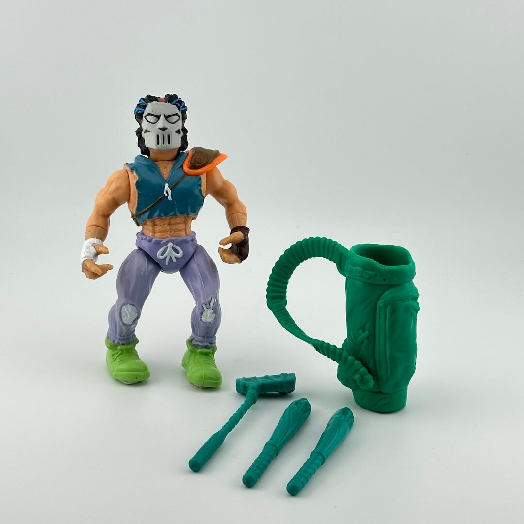 White male action figure in lavender sweatpants and torn blue vest with teal golf bag and accessories.