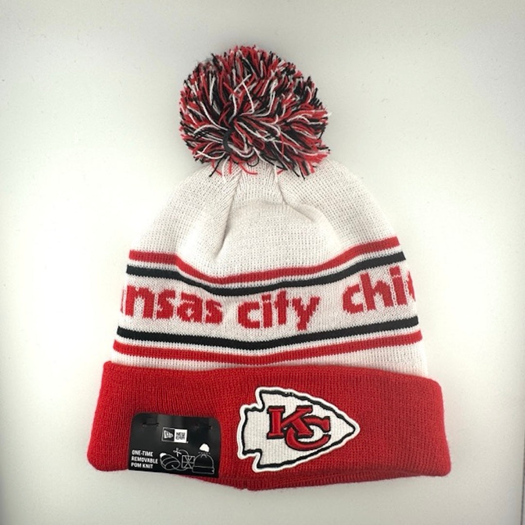White knit cap with red/black stripes around red team name, red cuff with Chiefs logo front center & black/white/red pom atop
