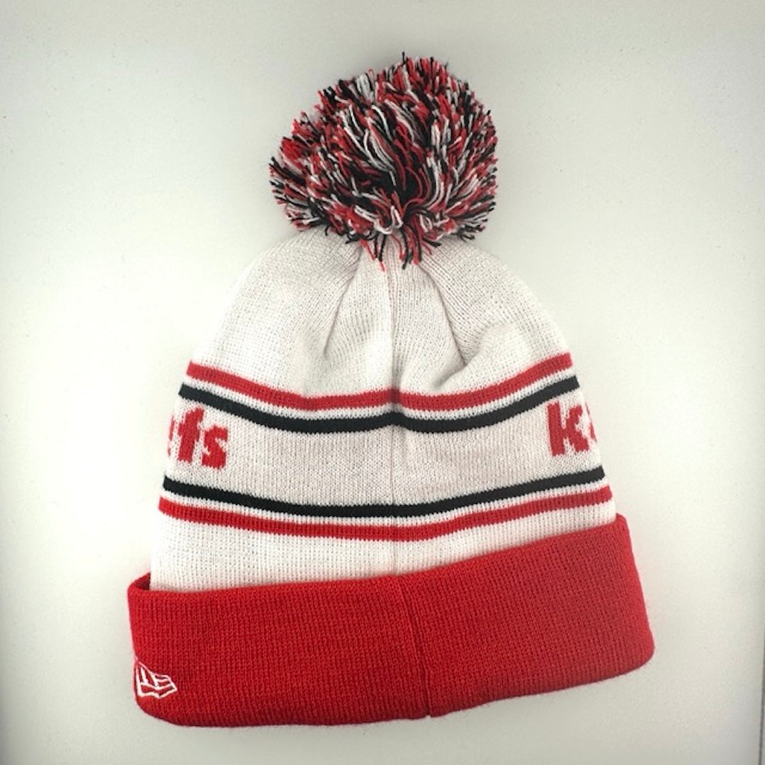 White knit cap with red/black stripes around red team name, red cuff with Chiefs logo front center & black/white/red pom atop