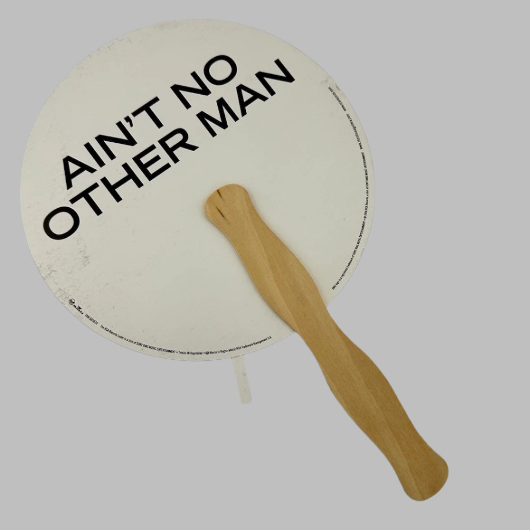 Backside of fan with "Ain't no other man" printed in bold, black text. Copyright info around edge.