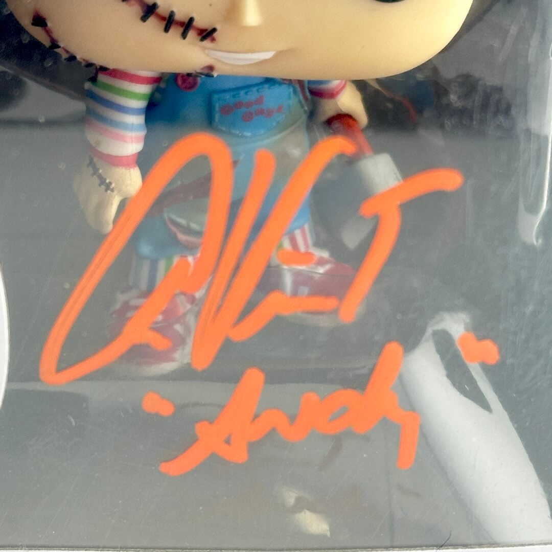 Toy figure in a clear plastic packaging with orange signature text.