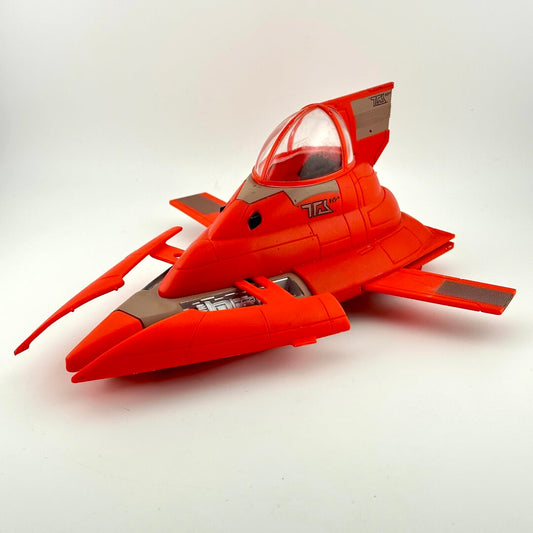 A red toy spaceship with gray panels and a clear canopy, photographed on a plain light gray background.