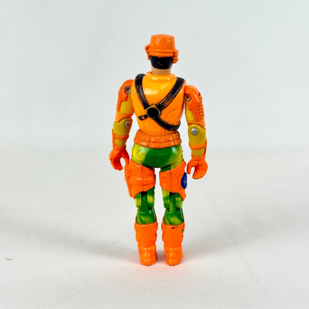 GI Joe action figure in orange vest, green pants with orange boots and helmet, standing against white background.