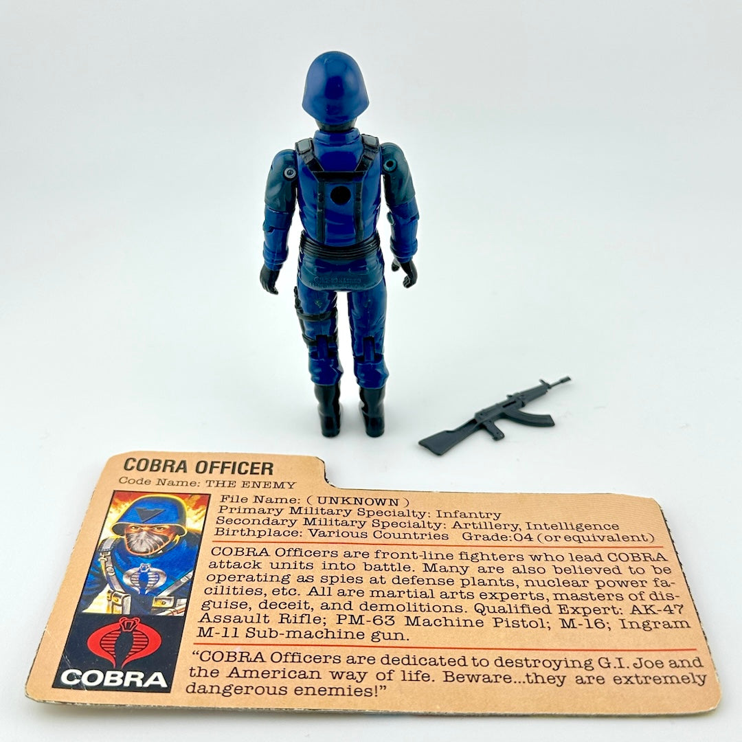 Cobra action figure with character card and gun accessory on white background.