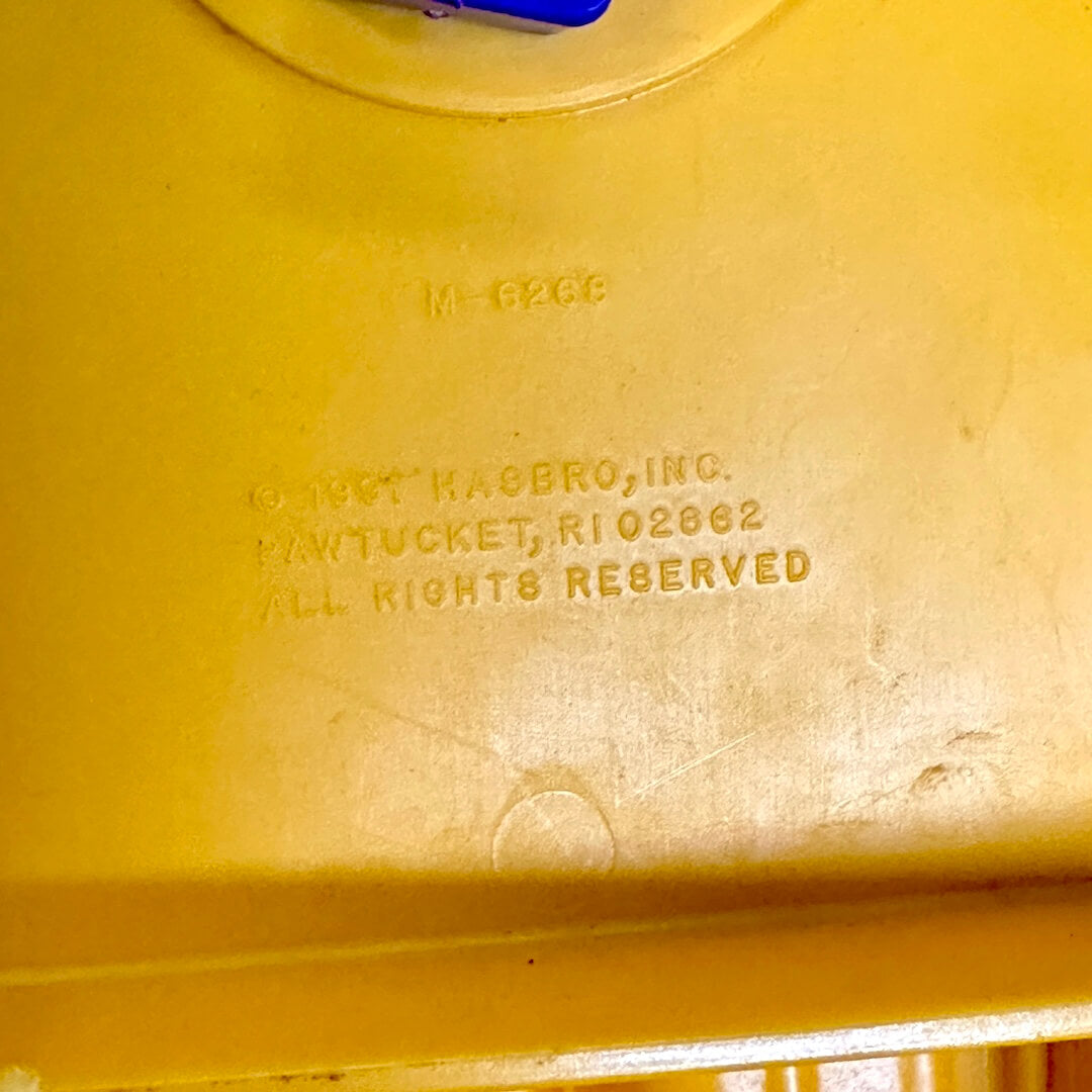 Orange toy with 'Hasbro, Inc.' branding and address on a orange background