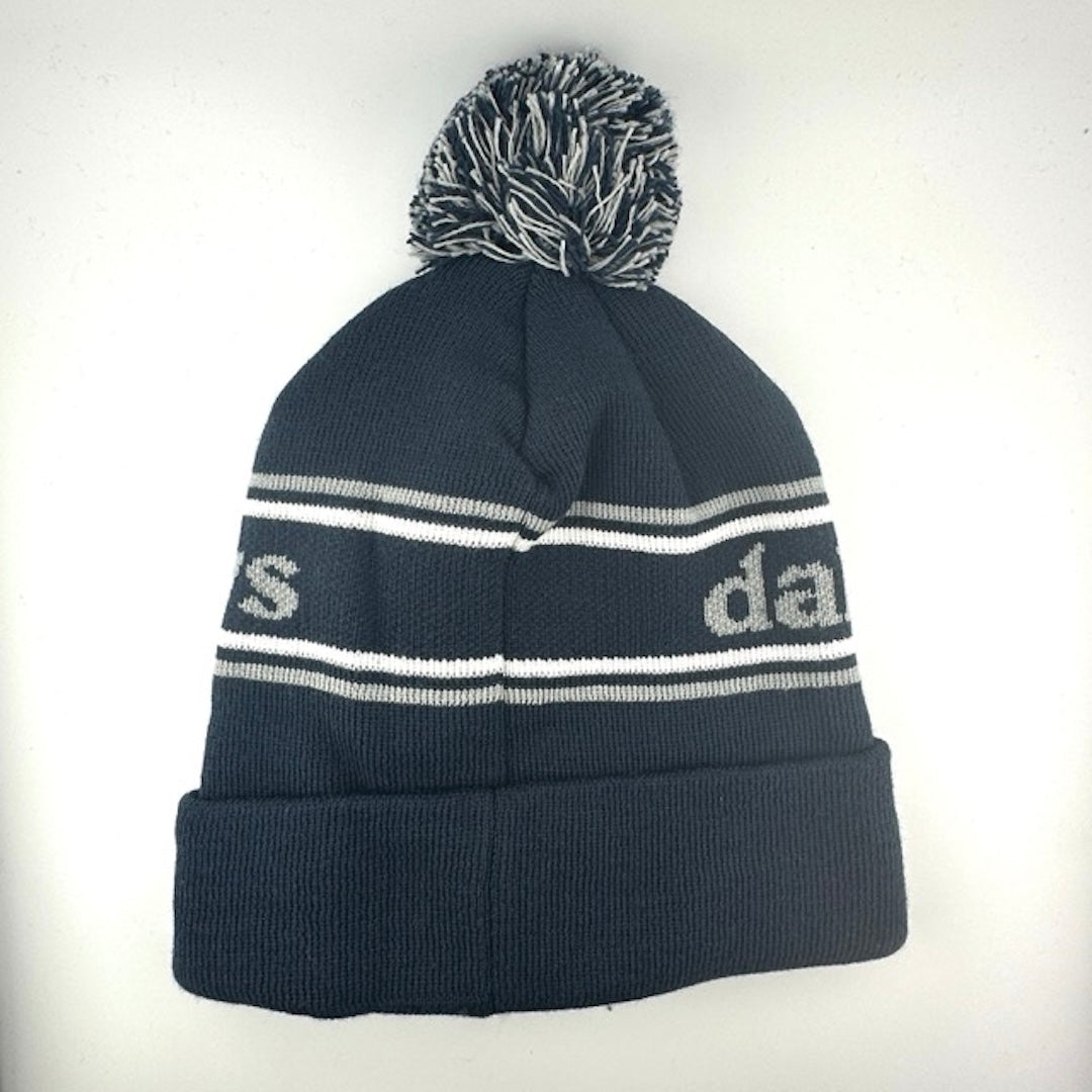 Navy knit hat with white/grey stripes around center banner featuring grey text. White/grey/navy pom at top.