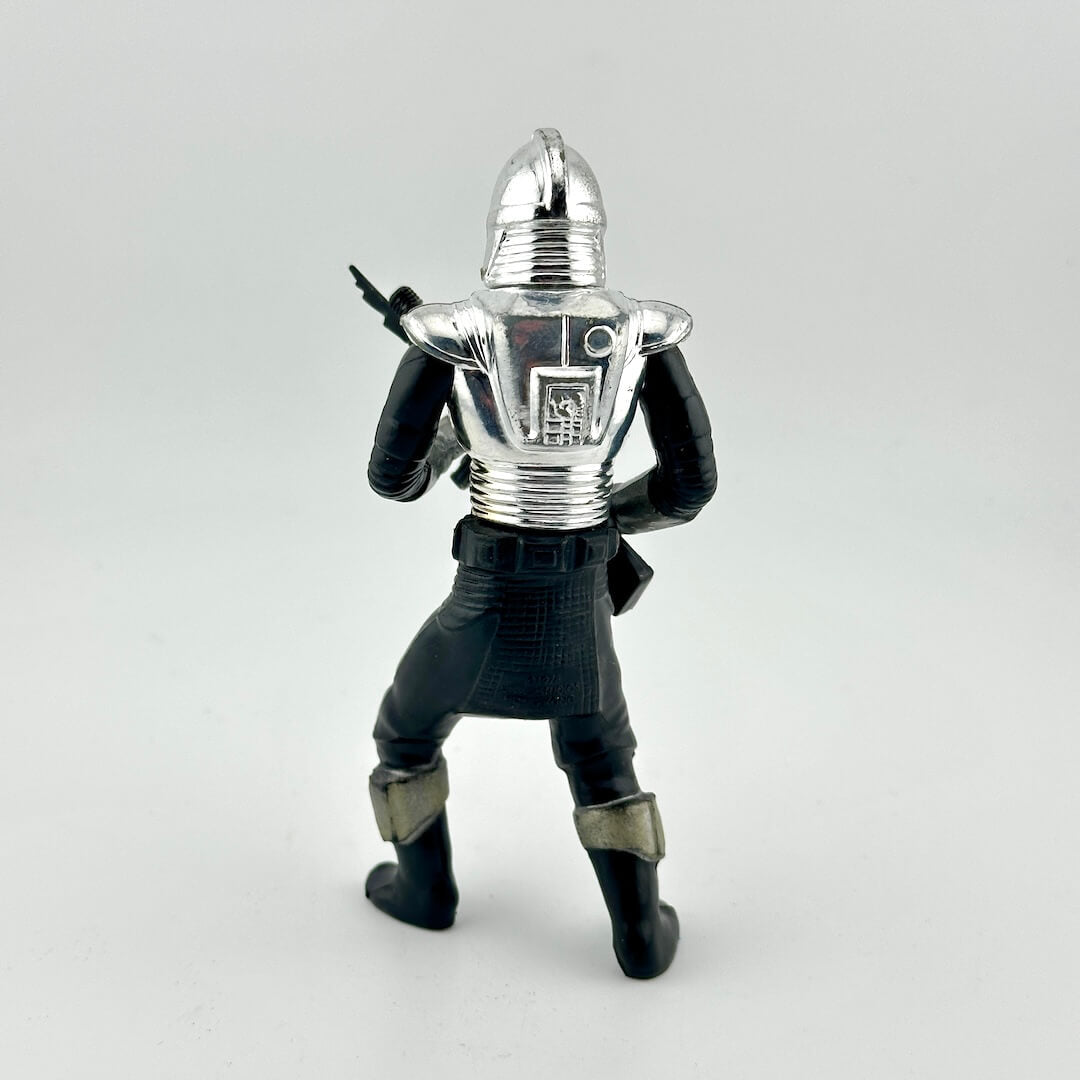Figurine of a character in a silver helmet and black suit on a light gray background