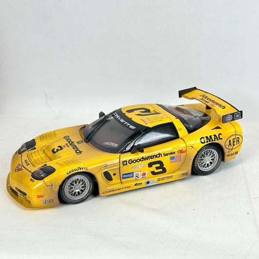 Yellow race car model with multiple sponsor logos on a white background