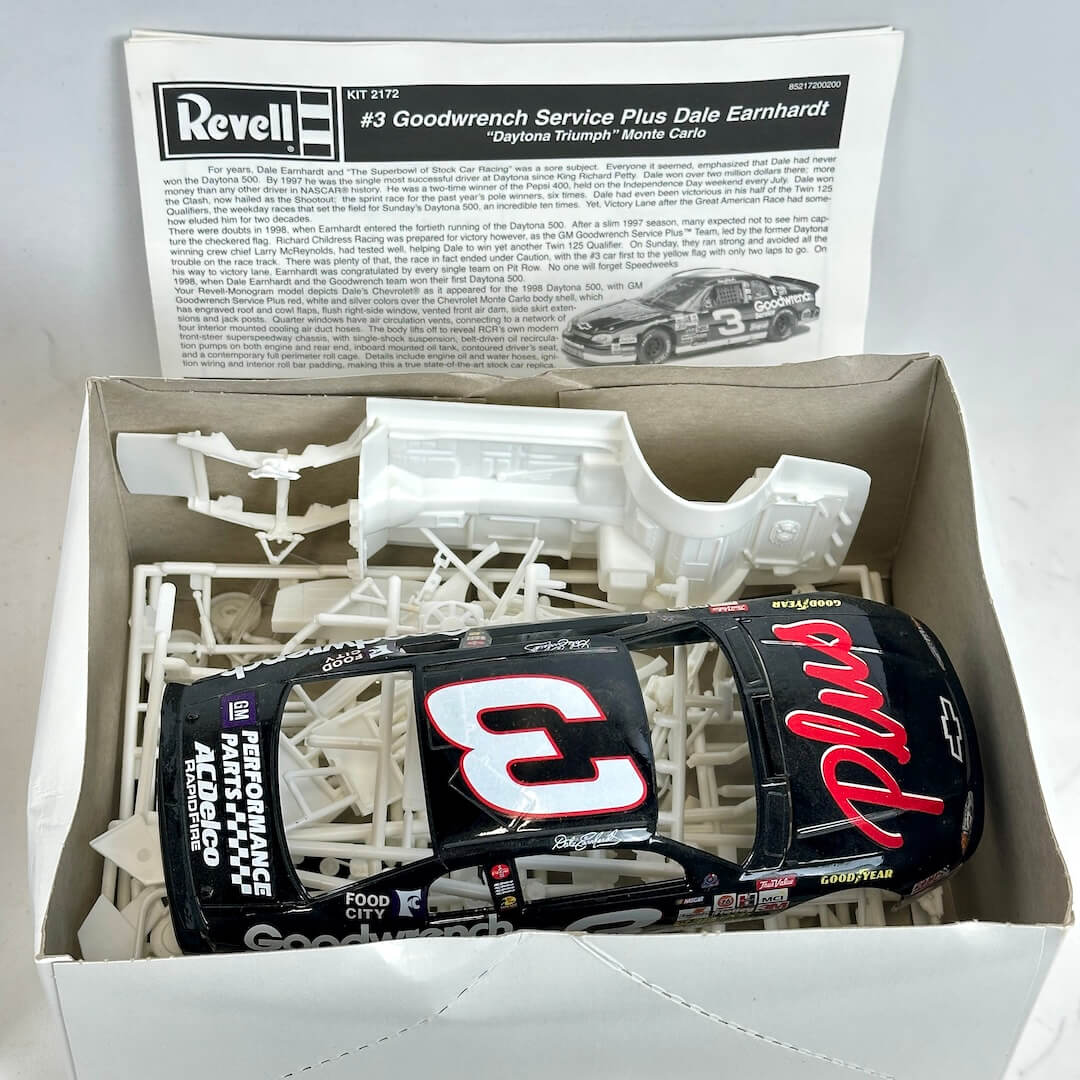 Model car kit with unassembled parts and a box featuring Dale Earnhardt branding.