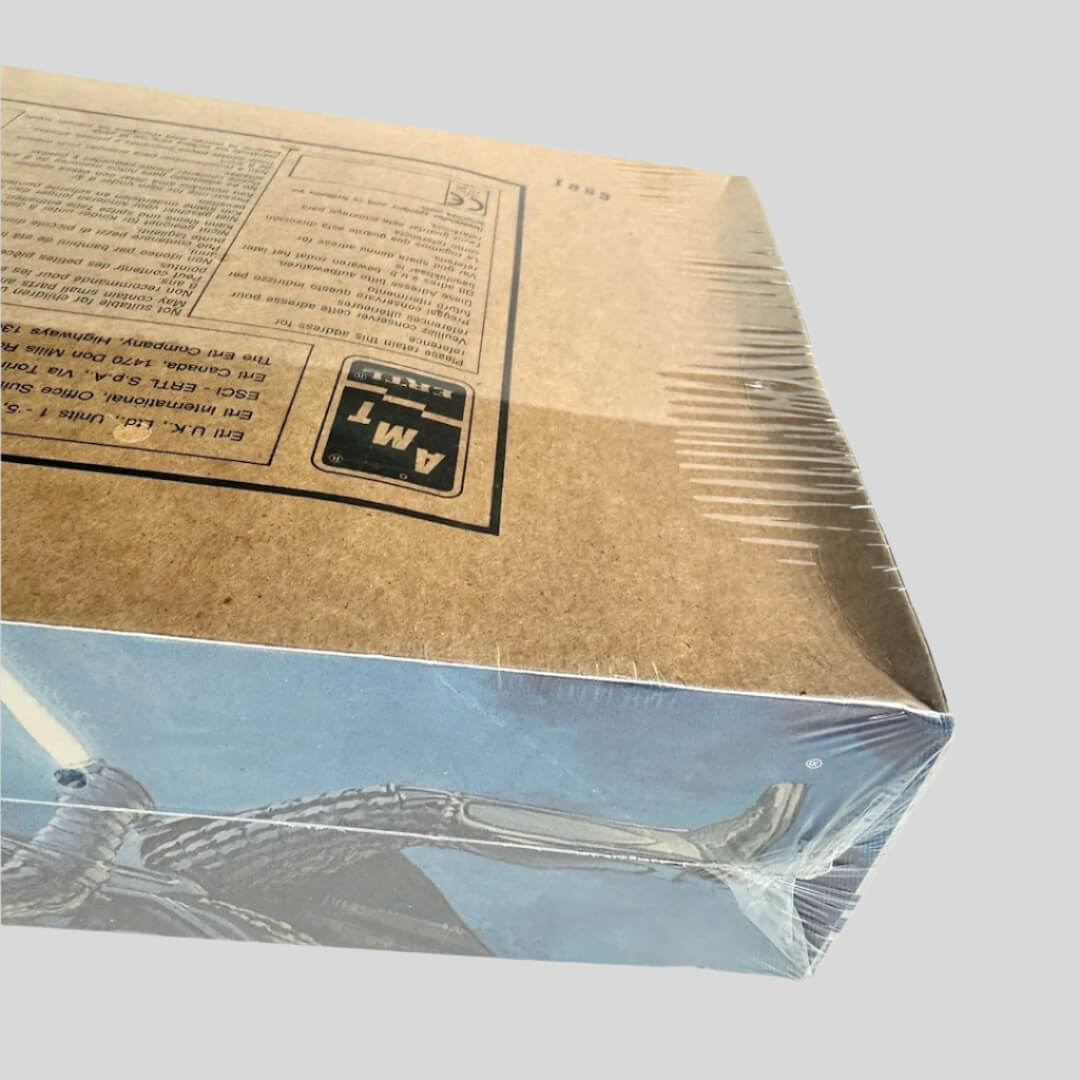 Top left corner of box at an angle to show the concave nature of the box but plastic still intact. No other damage.